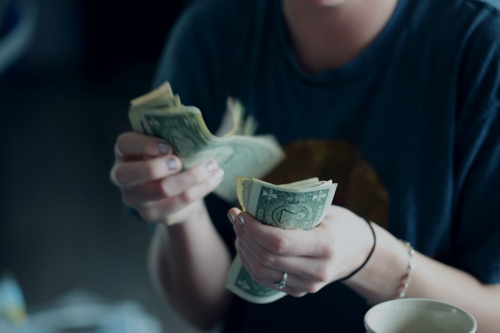 woman's hands counting dollar bills