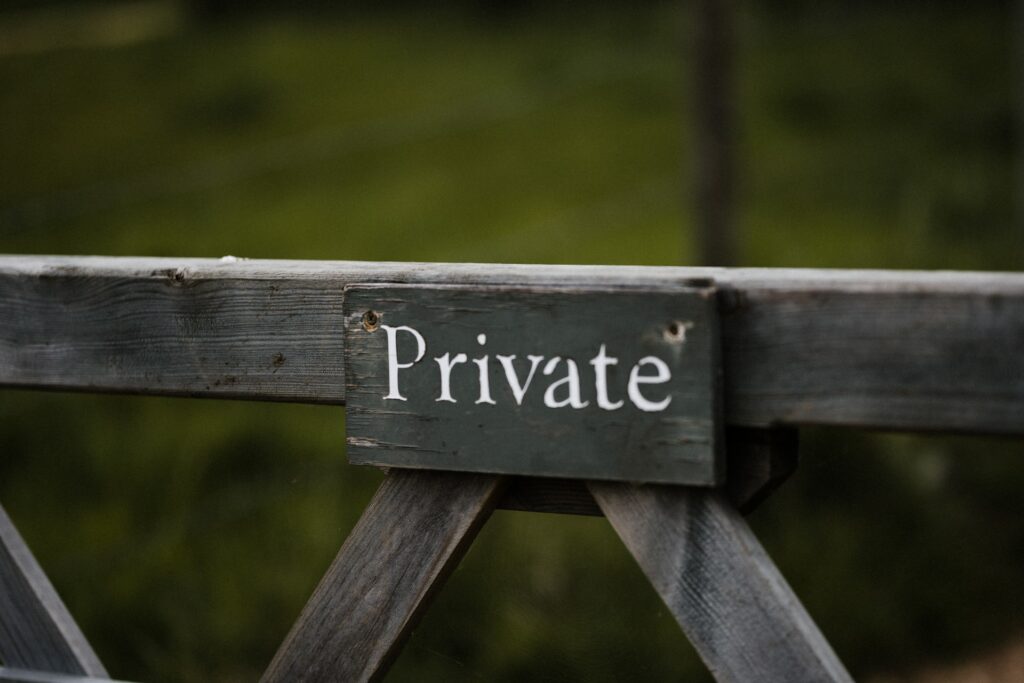 wooden sign that says private to scare trespassers