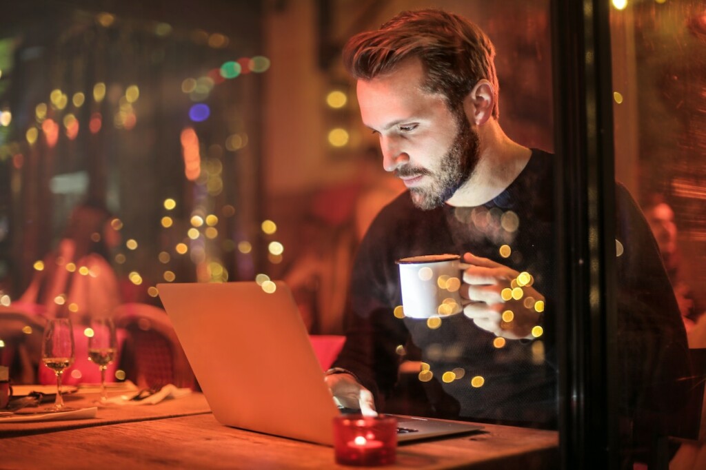 Man Holding Mug in Front of Laptop searching how to sell a large piece of land