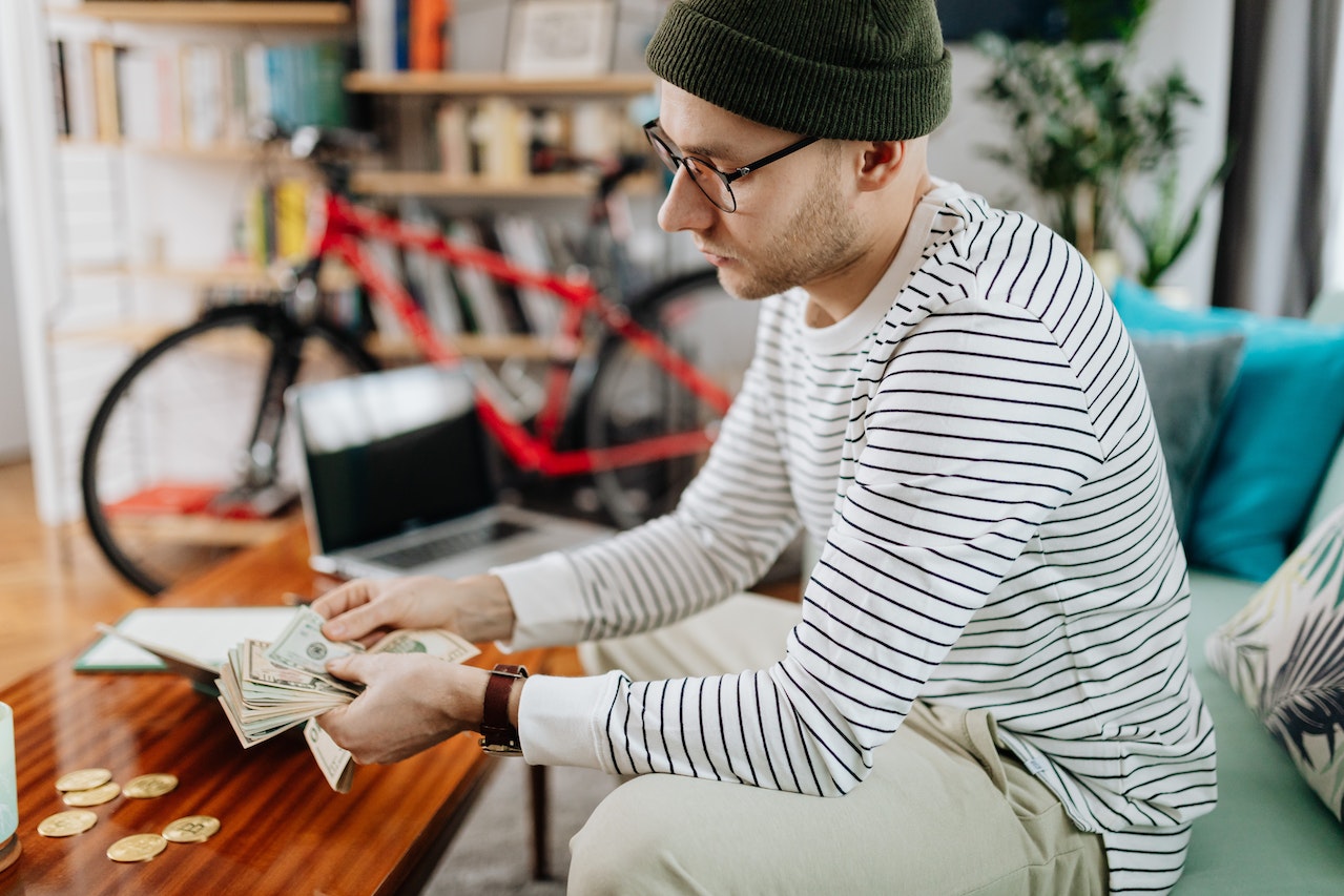 A man counting his money after a sale from we buy land for cash site